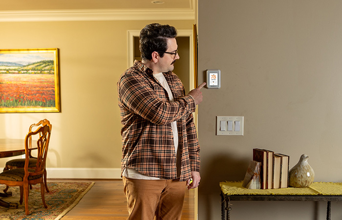 Man setting thermostat to off-peak electricity hours