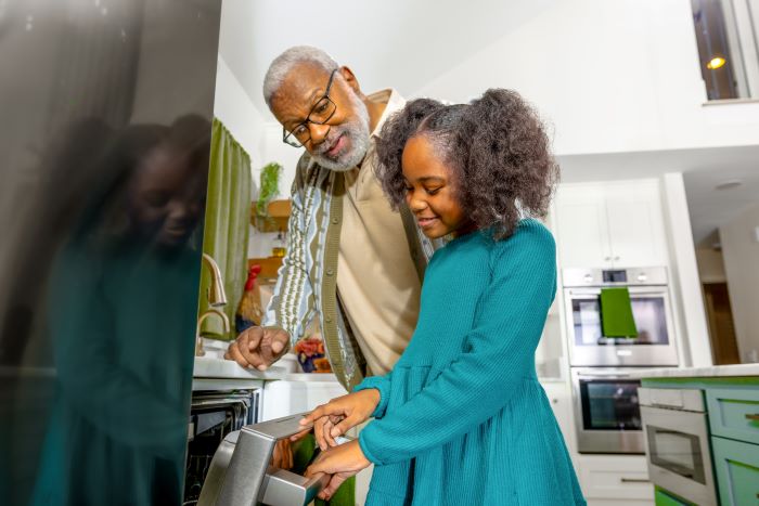 Girl and her grandfather starting the dishes after peak hours