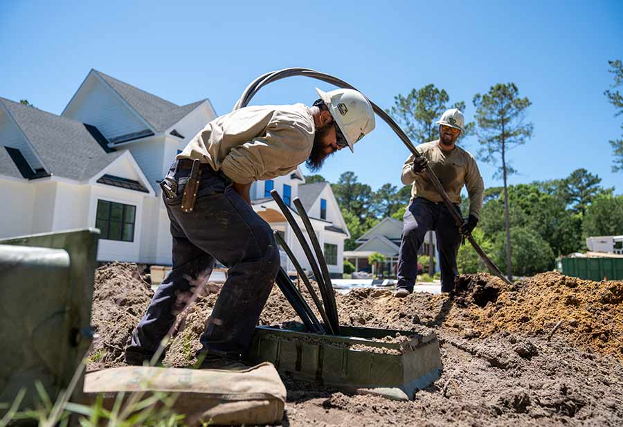 Electrical workers adding underground power lines